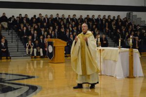 Fr. Hagan speaks during Mass with student body seated behind him